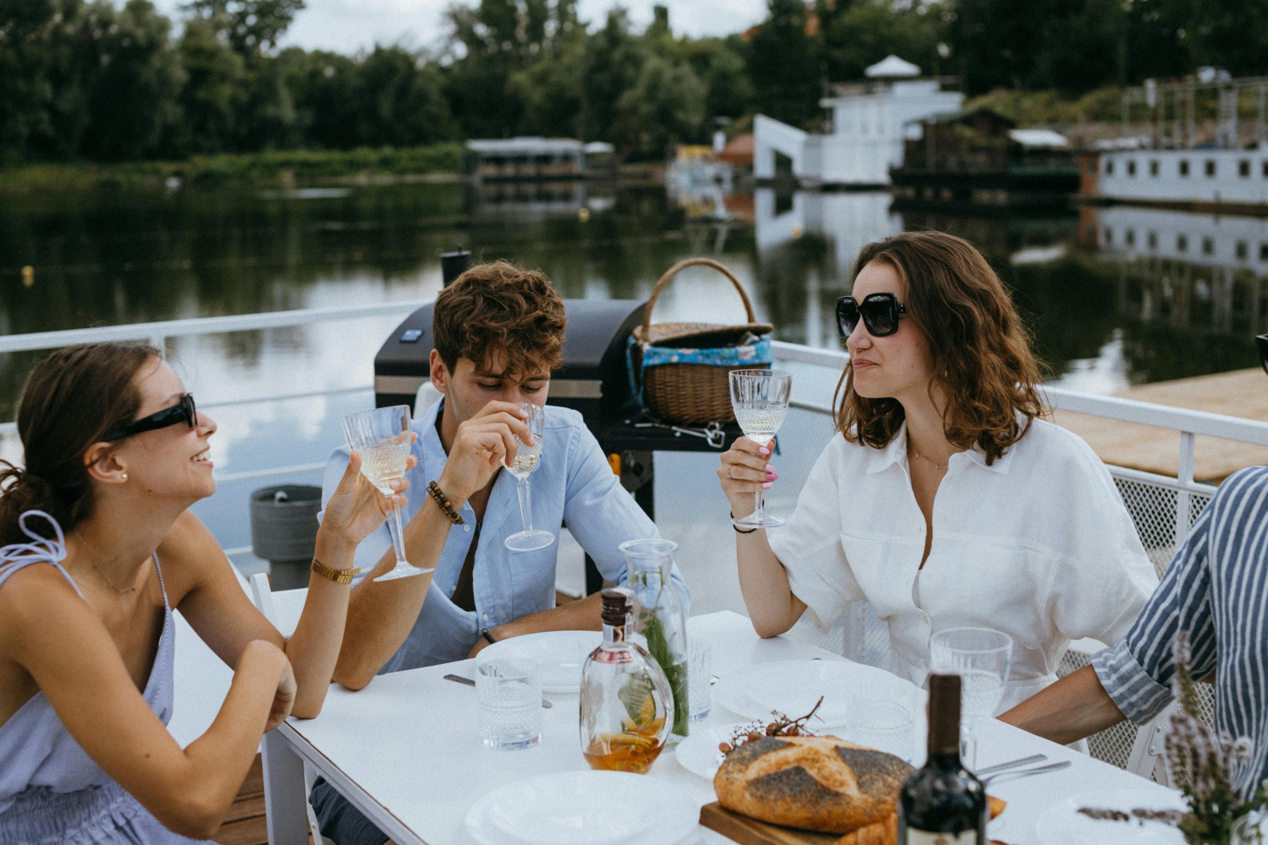 Friends enjoying drinks and conversation on a yacht in summer.